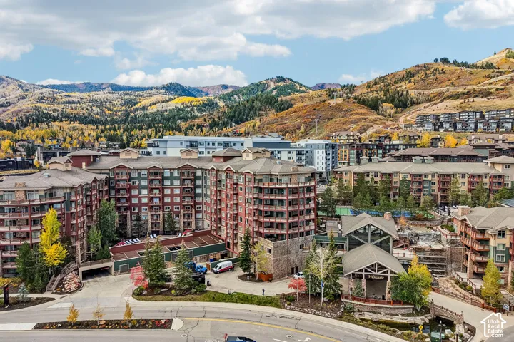Multi-story residential complex featuring stone and siding exterior, private balconies, and surrounding mountain scenery