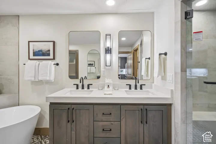 Double vanity featuring wood-finish cabinetry, white countertop, dual undermount sinks with matte black fixtures, and two rectangular wall-mounted mirrors