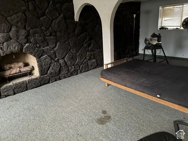 Full-height dark stone accent wall featuring an integrated arched masonry fireplace