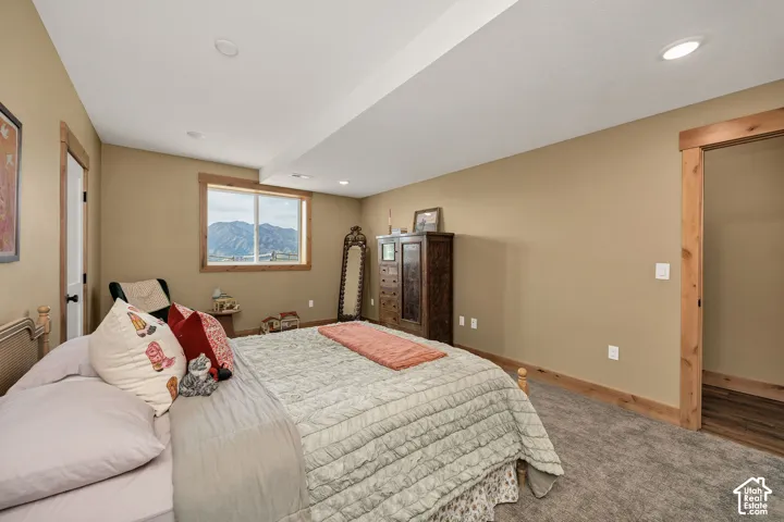 Neutral-toned interior featuring natural wood window and door trim, recessed lighting, carpeted flooring, and a mountain backdrop