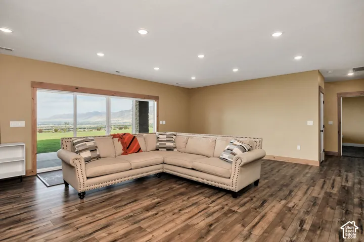 Recessed lighting, wood-finish flooring, natural wood trim, and large sliding glass door with mountain scenery