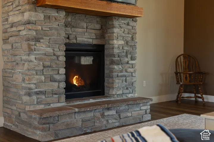 Floor-to-ceiling stone fireplace surround with a natural wood mantel and stone-capped hearth