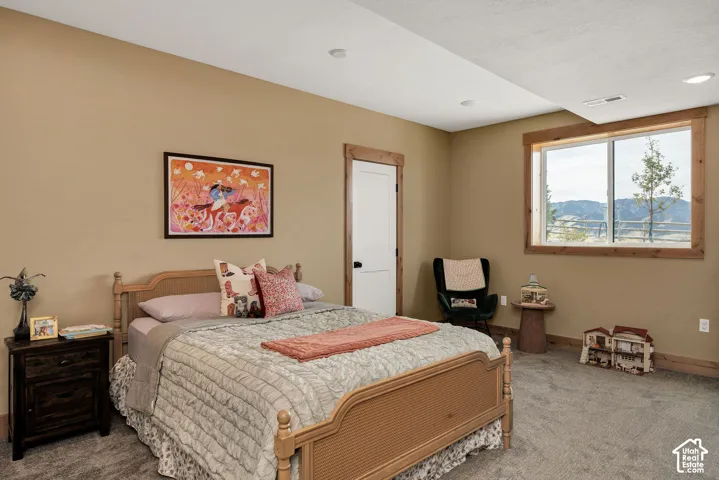 Neutral-toned walls, wood-trimmed windows, solid-core interior door with wood casing, plush carpeting, and recessed lighting