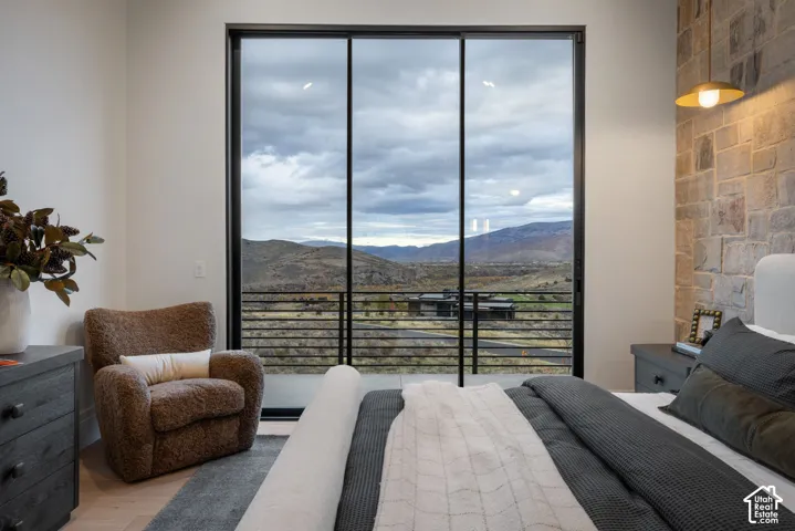Floor-to-ceiling sliding glass door system, stone accent wall, metal cable railing, and pendant lighting
