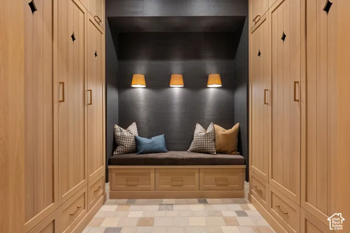 Floor-to-ceiling built-in cabinetry featuring light wood finish, integrated drawer storage, and diamond-pane accent detailing