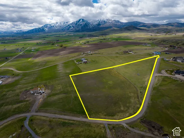 Overview of rural landscape featuring property boundaries highlighted and a mountain backdrop
