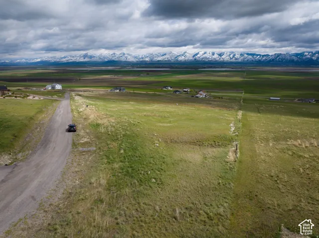 Overview of rural landscape featuring a mountain backdrop and large plots for crops