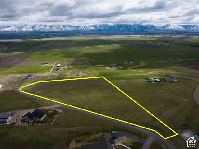 Overview of rural landscape featuring property boundaries highlighted and a mountain backdrop