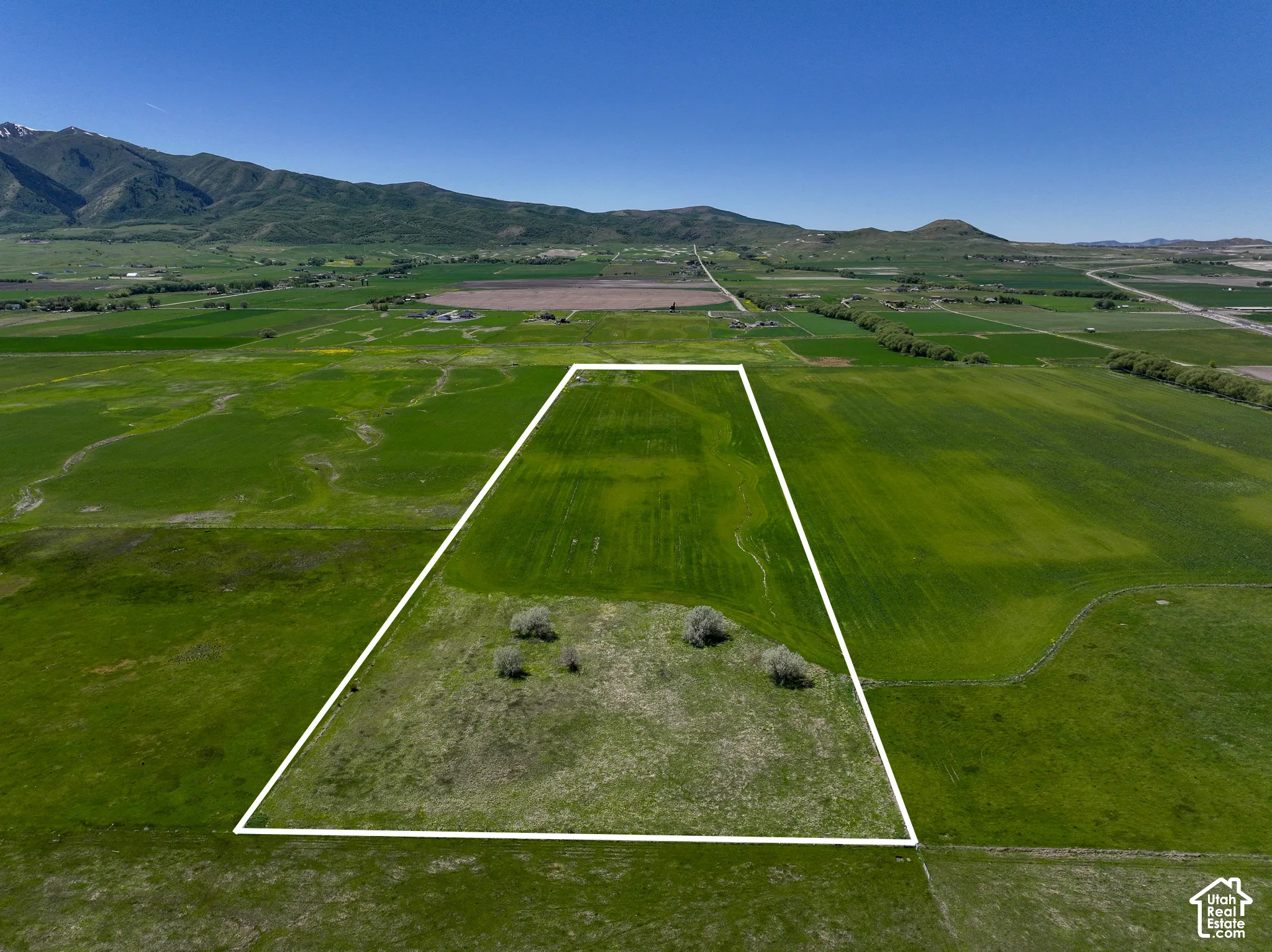 Expansive acreage featuring cleared level terrain and a backdrop of mountain ranges