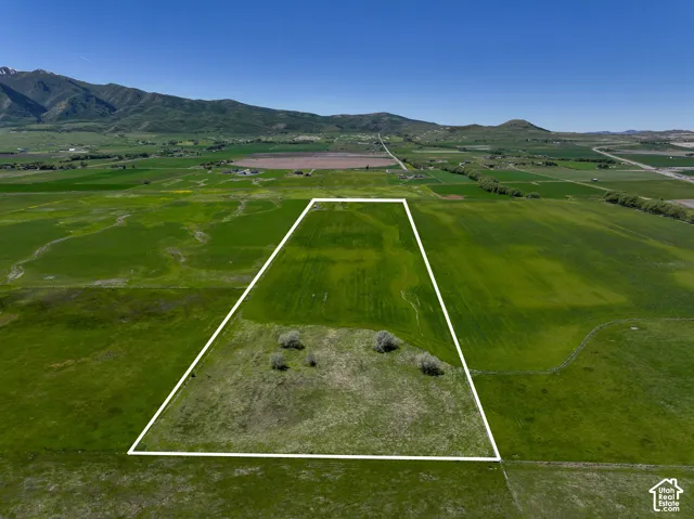 Expansive acreage featuring cleared level terrain and a backdrop of mountain ranges