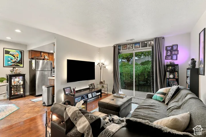 Living area featuring wood-finish flooring, recessed lighting, and sliding glass doors with exterior access