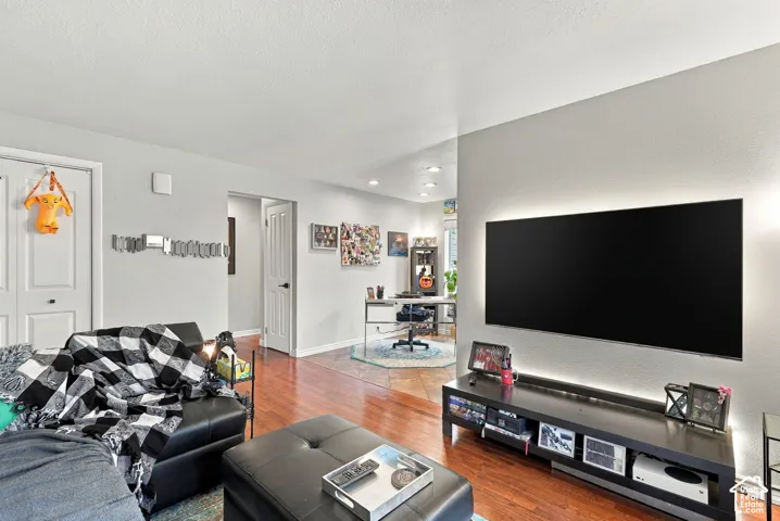 Interior space featuring recessed ceiling lighting, wood-finish flooring, multi-panel doors, and an accent wall with integrated backlighting