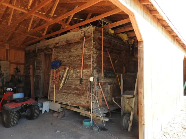 Enclosed storage structure featuring exposed timber-frame ceiling trusses and heavy-timber wall construction