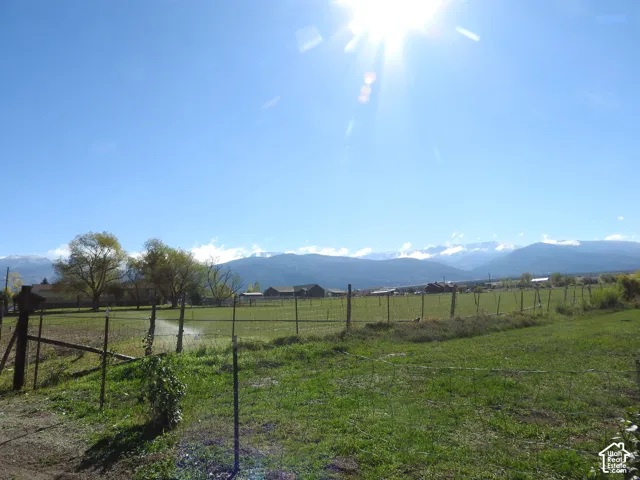 Expansive acreage featuring open pasture land, perimeter wire fencing, and mountain scenery