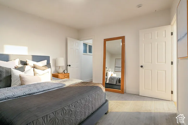 Neutral interior featuring wood-finish flooring, white paneled doors, and matte black door hardware