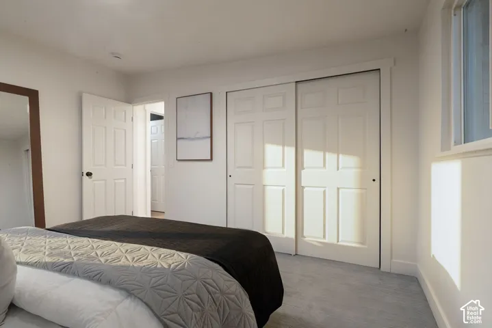 Bedroom featuring neutral wall paint, carpeted flooring, and a sliding dual-panel closet