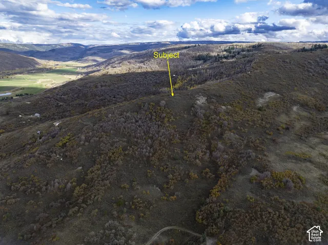 Elevated acreage featuring expansive mountain topography, dense native vegetation, and sweeping horizon terrain