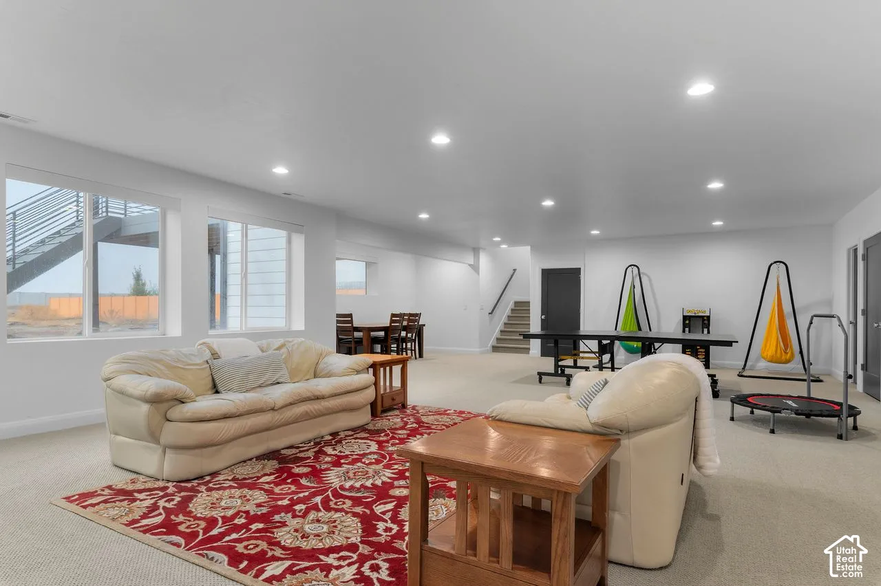 Open-concept interior space featuring recessed ceiling lighting, wall-to-wall carpeting, and large windows