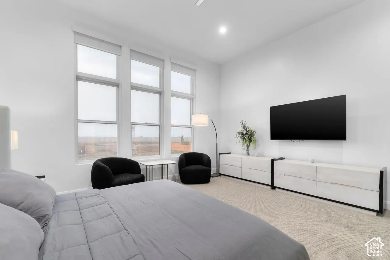 High-ceiling room featuring large multi-panel windows, neutral wall-to-wall carpeting, and recessed lighting