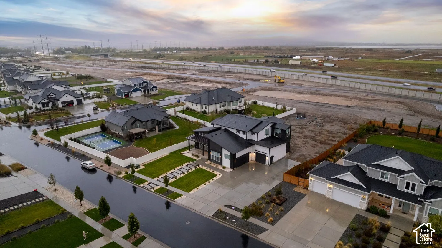 Aerial perspective of residential neighborhood featuring modern multi-gabled rooflines, contrast exterior siding, concrete driveways, and manicured lawns