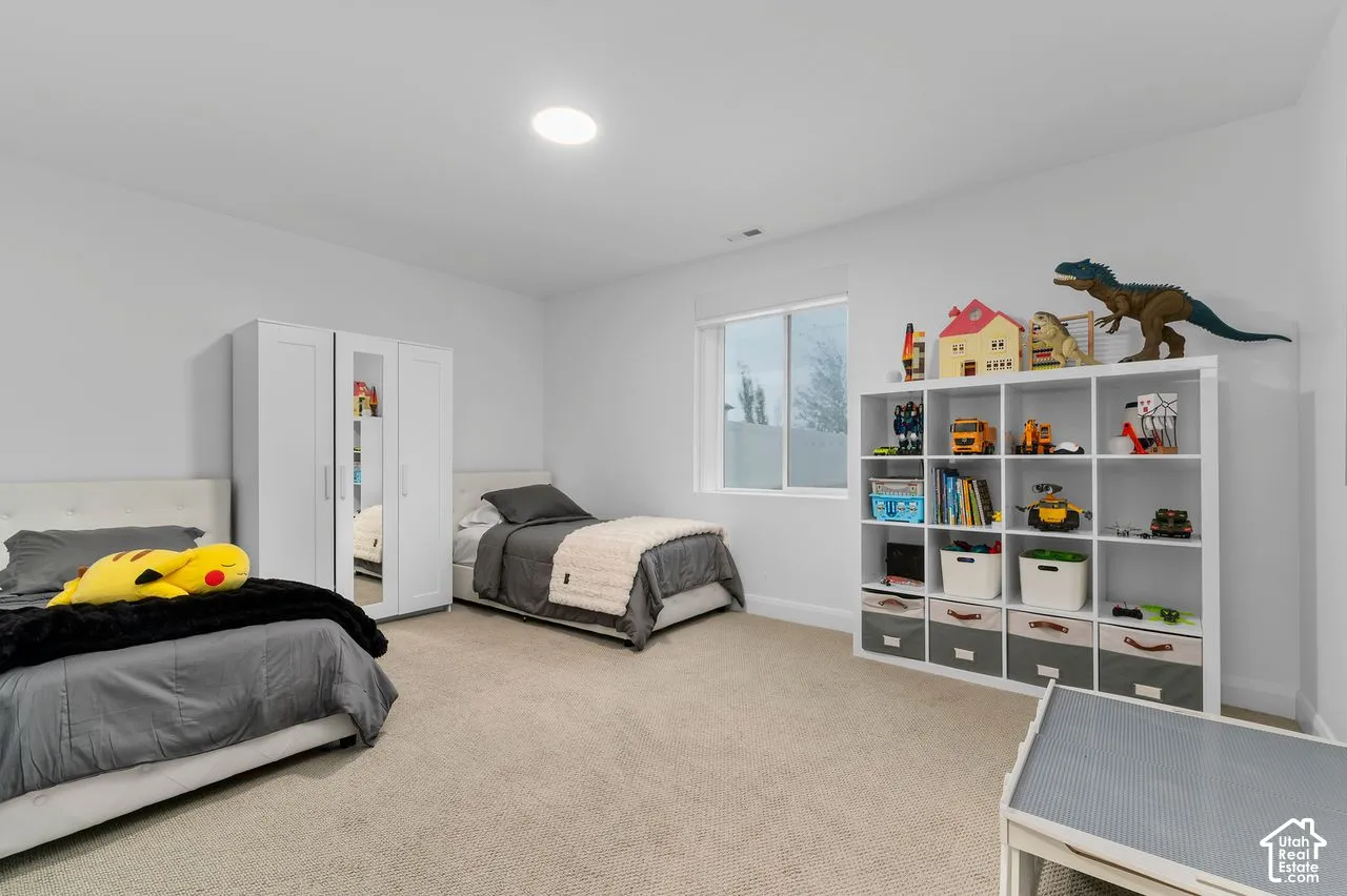 Neutral-toned interior space featuring neutral wall-to-wall carpeting, a large sliding-sash window, and a recessed ceiling light fixture
