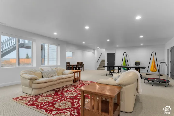 Open-concept interior space featuring recessed ceiling lighting, wall-to-wall carpeting, and large windows