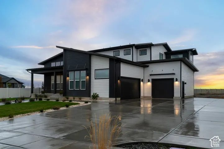 Modern exterior featuring high-contrast horizontal siding, a multi-car garage, a concrete driveway, and expansive windows