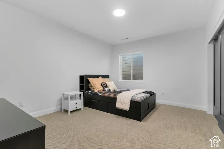 Neutral-toned interior featuring wall-to-wall carpeting, a recessed ceiling light, a sliding glass window, and a dark-toned door