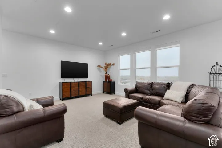 Neutral wall color, recessed lighting, and expansive windows with natural illumination