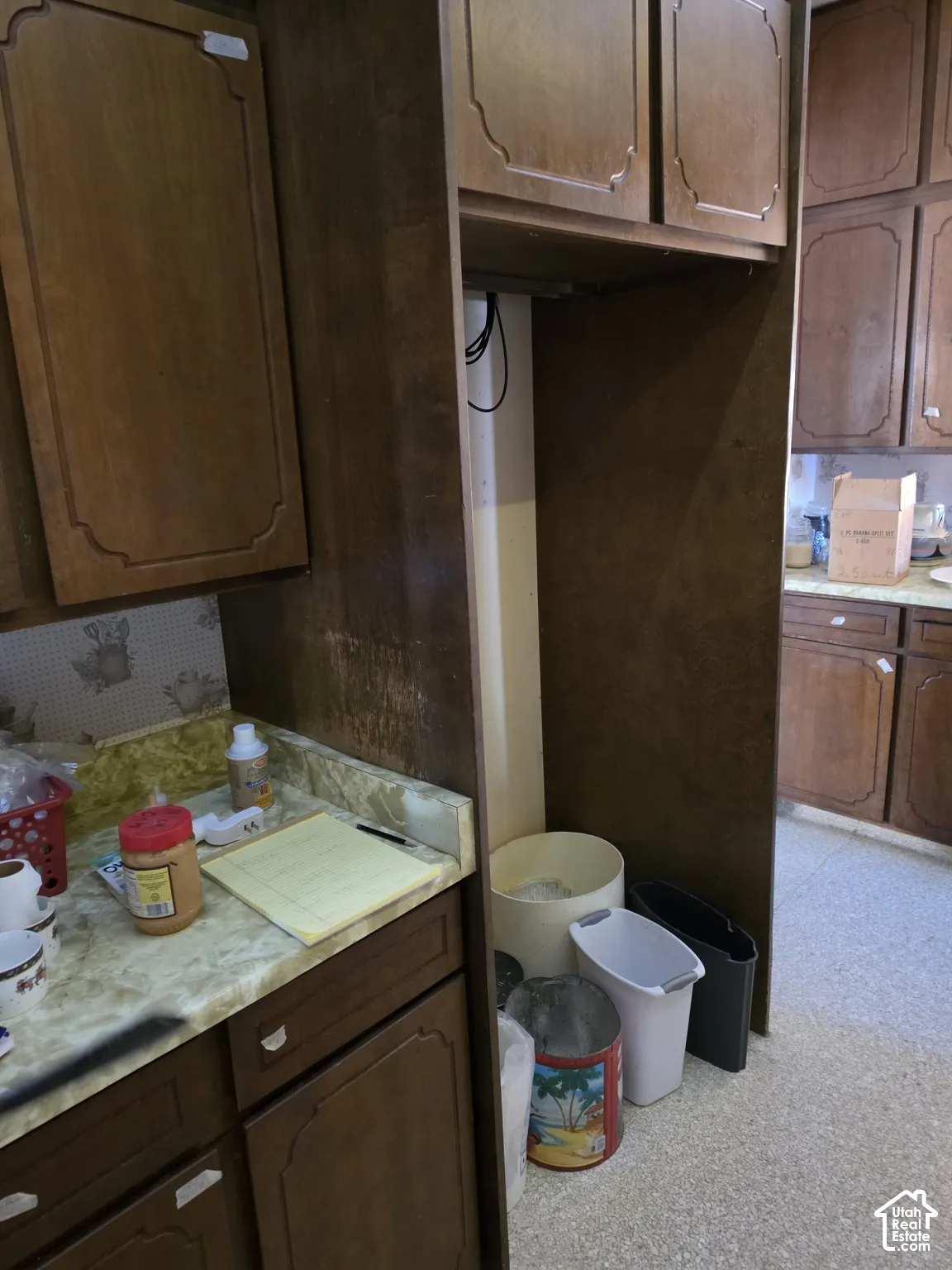 Kitchen featuring stained wood cabinetry with recessed panel doors, overhead storage, and stone-finish laminate countertops