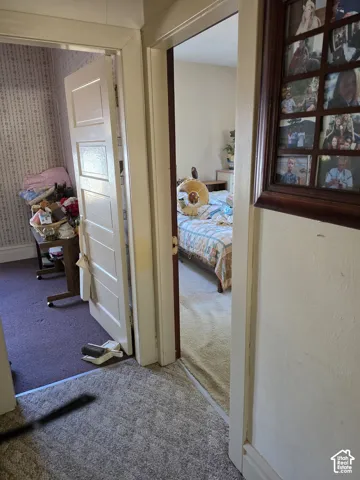 Interior hallway featuring multi-panel wood doors, wide door casings, and patterned wall covering