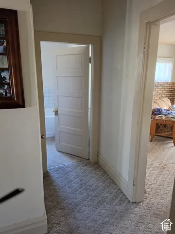 Interior hallway featuring neutral carpeting, painted door frames, and five-panel solid-core doors