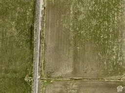 Aerial perspective of expansive open acreage featuring level topography and direct road frontage