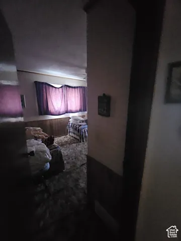Room featuring wood-paneled wainscoting and wall-to-wall carpeting
