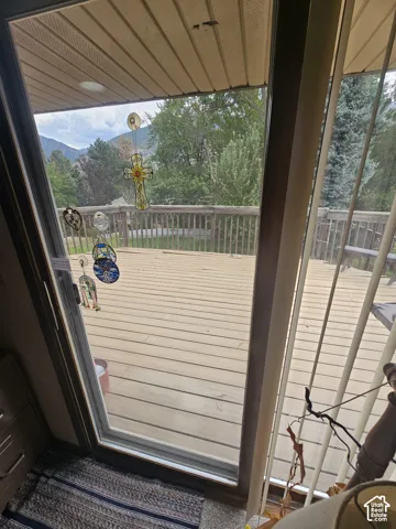 Exterior wood-plank deck featuring a balustrade railing and mountainous scenery