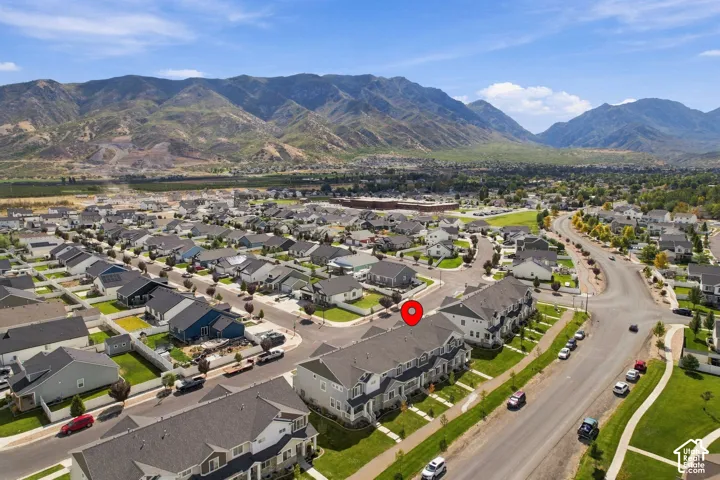Aerial perspective of multi-unit residential structure featuring asphalt shingle roofing, exterior siding, and mountain range backdrop