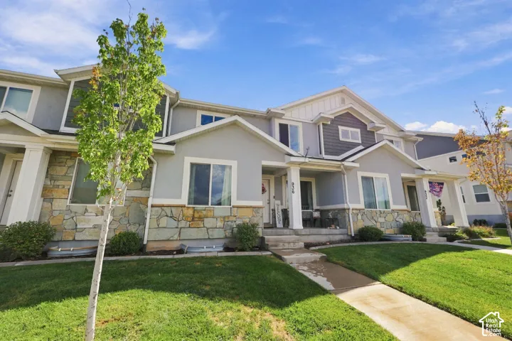 Multi-level exterior featuring a stone veneer lower facade, fiber cement siding, gabled rooflines, and a covered front porch with square columns