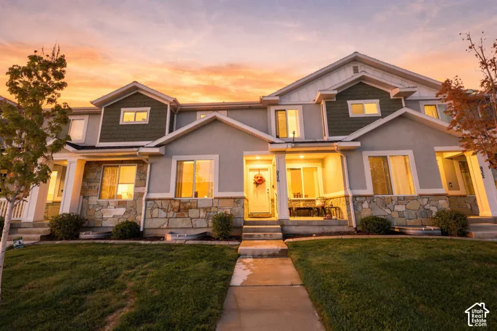 Exterior facade featuring multi-gabled rooflines, stone veneer skirting, shake siding accents, and concrete entry steps