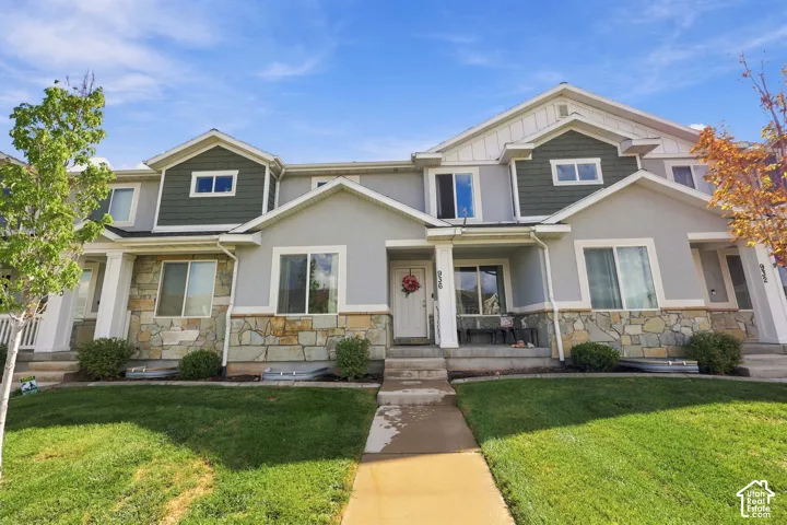 Multi-story exterior featuring stone veneer accents, contrasting siding, gabled rooflines, and a concrete walkway