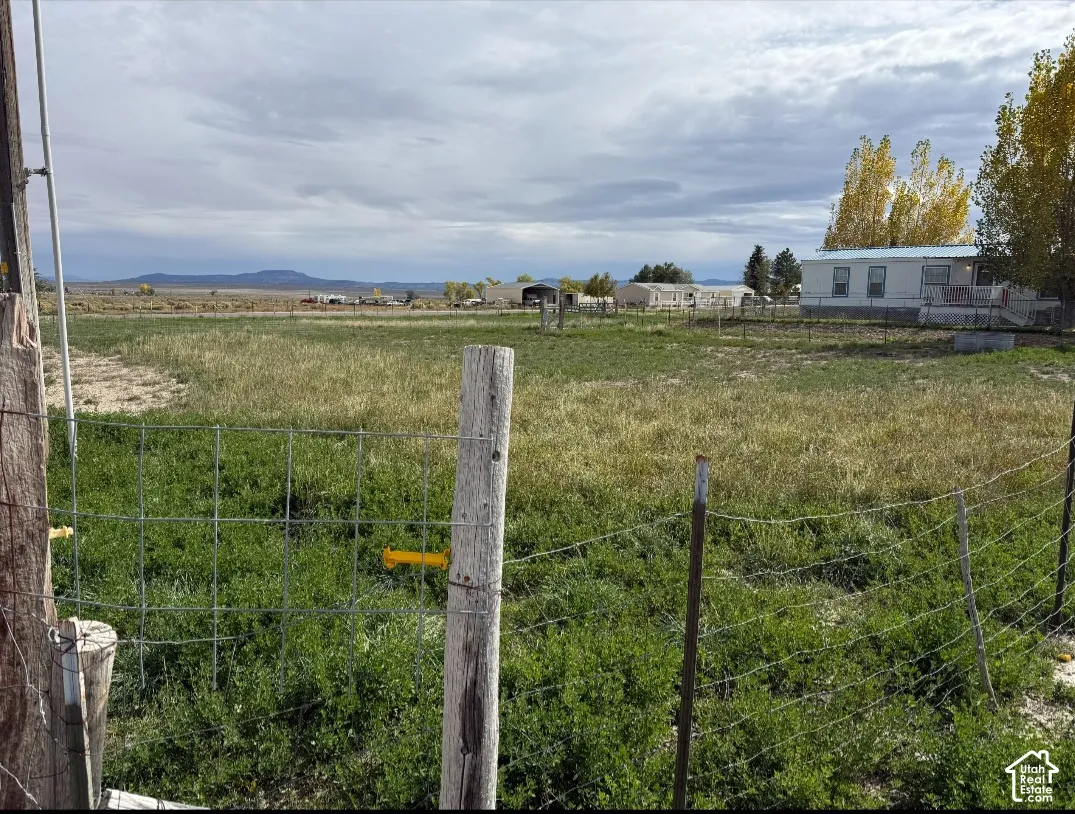Expansive lot featuring wire fencing and mountain horizon