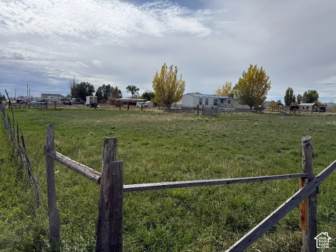 Expansive acreage featuring mature trees, open pasture, and split-rail perimeter fencing