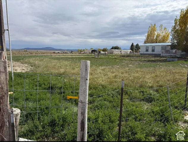 Expansive lot featuring wire fencing and mountain horizon