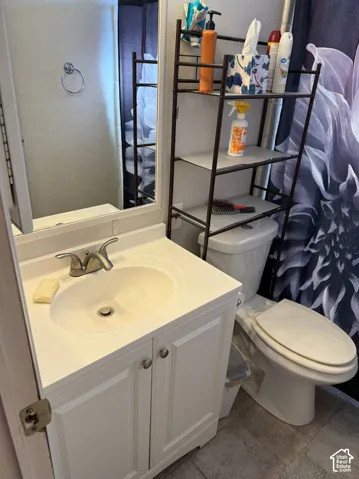 White vanity cabinet with an integrated sink, dual-handle faucet, framed wall mirror, and ring towel holder