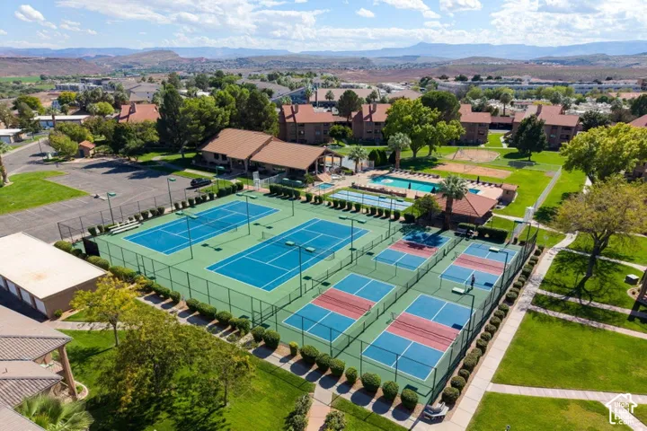 Recreational complex featuring multiple tennis courts, pickleball courts, an outdoor swimming pool, and manicured green spaces