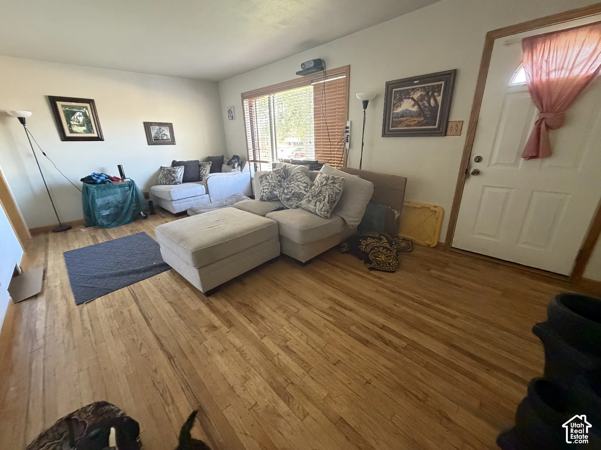 Hardwood flooring and large window with blinds