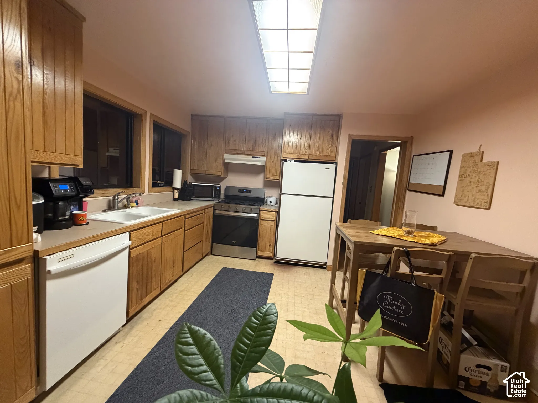 Kitchen featuring wood cabinetry, stainless steel range, dual-basin sink, and recessed ceiling lighting