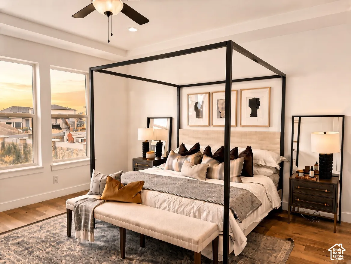 Bedroom featuring wood-finish flooring, recessed tray ceiling, ceiling fan with integrated lighting, and expansive windows