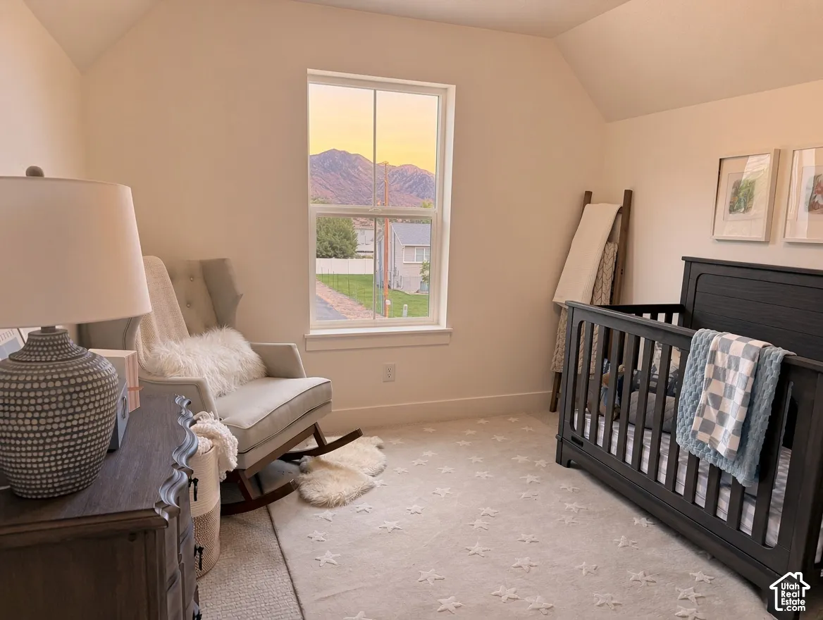 Room featuring vaulted ceilings, neutral wall tones, and a double-hung window framing a mountain backdrop