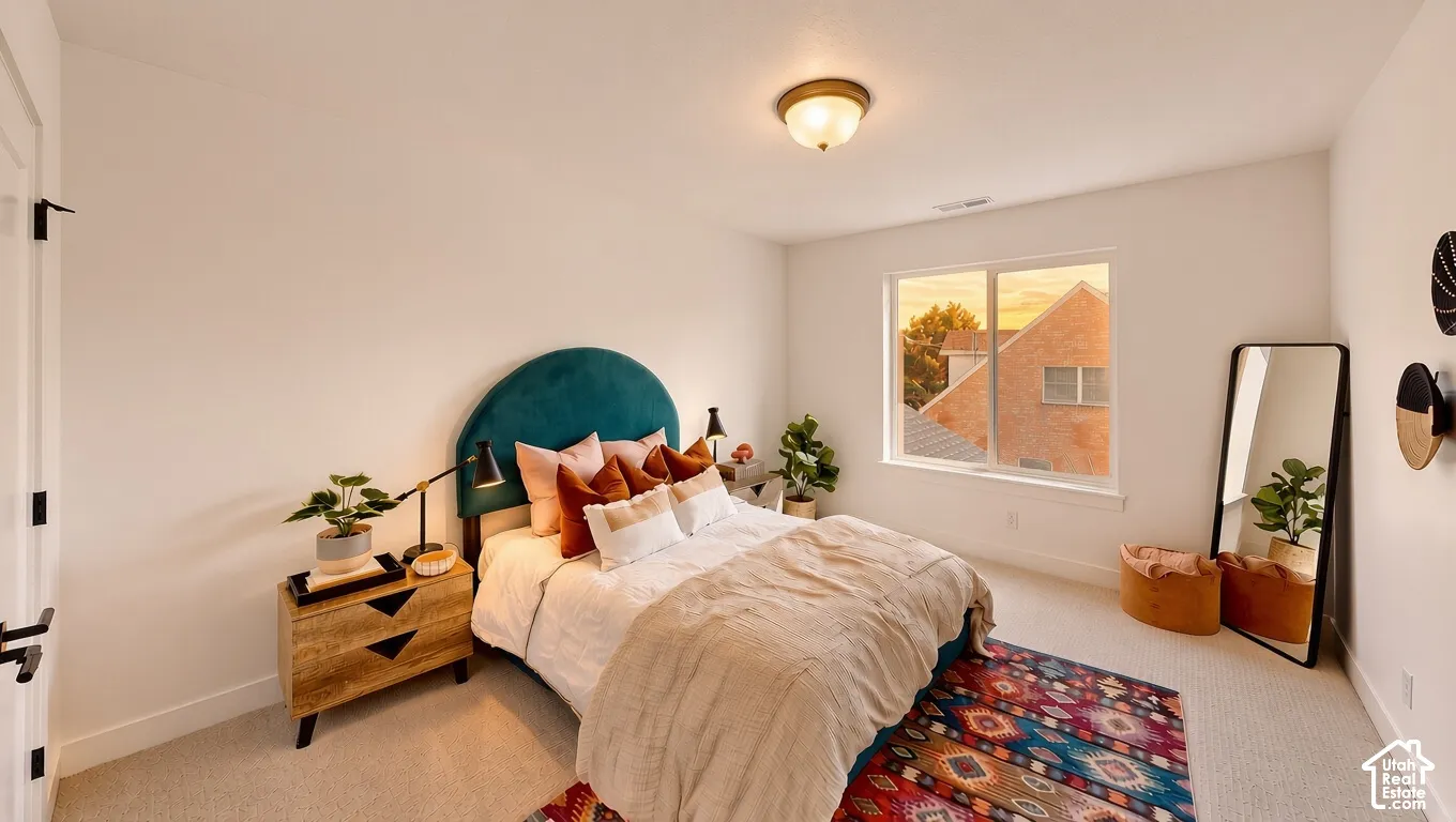 Bedroom featuring neutral wall-to-wall carpeting, a flush-mount ceiling light fixture, and a large window