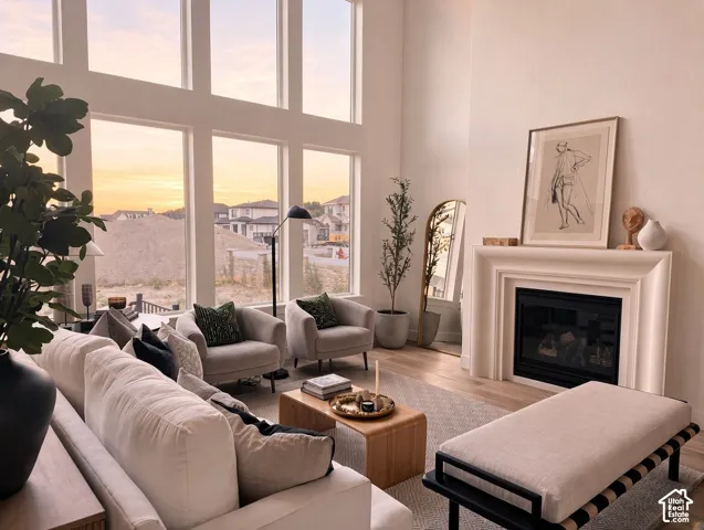 Double-height ceiling, floor-to-ceiling multi-pane windows, and a sculptural fireplace surround featuring a gas-insert firebox
